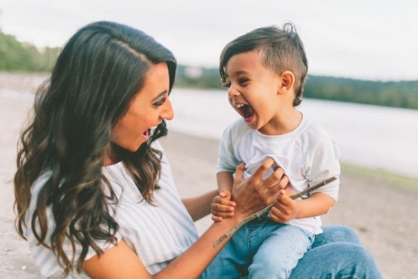 Mother and child laughing on a beach