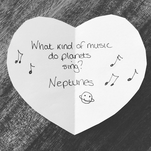Science joke for kids on a white paper heart: What kind of music do planets sing? Neptunes!