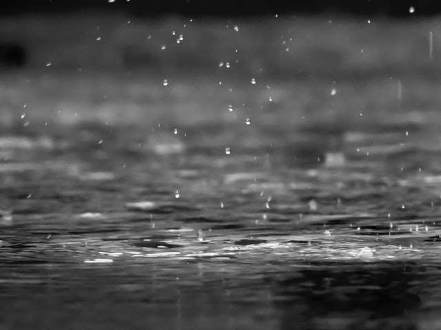 Rain drops falling into water