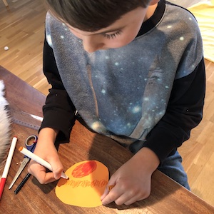 Child colouring in a scale drawing of Jupiter