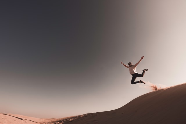 Man jumping on sand dunes in a Martian-like landscape